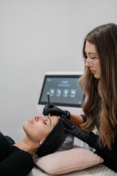 Aesthetics practitioner facial mapping clients face for treatment