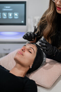 Aesthetics practitioner facial mapping clients face for treatment