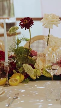 Vertical video. Wedding table decorated with flowers, candles, lemons and festive tableware.