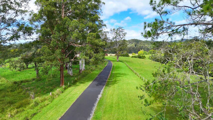 Obraz premium Aerial View of a Narrow Asphalt Road Through Lush Bellingen Countryside