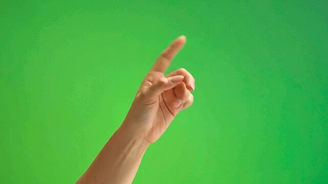 A human hand gesturing with one finger against green background