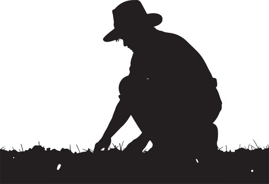 Silhouette of a man planting seeds in grassy field person