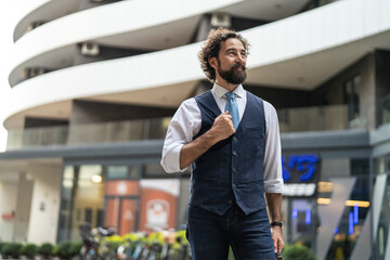 Fototapeta premium Confident man with beard laughing outdoors in urban setting
