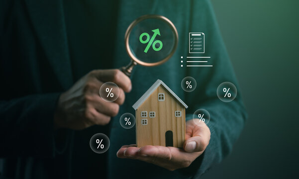 Mortgage interest rate concept with a wooden house model and magnifying glass, representing home loans, real estate financing, property investment, refinancing, and housing market analysis.