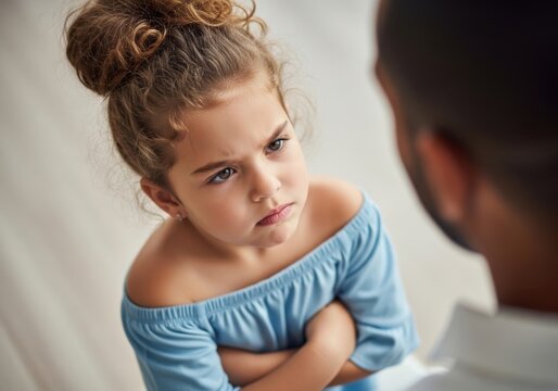 Young girl looking at her father with a serious and upset expression