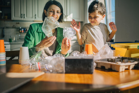 Mother and son sorting plastic waste at home for recycling