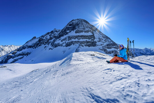 Austria, Tyrol, Sun shining over female skier taking break at Torhelm mountain