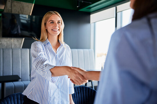 Smiling recruiter shaking hands with candidate at office