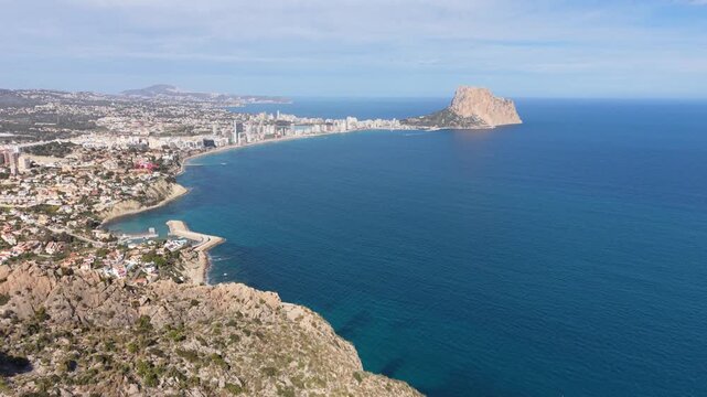 Side drone flight along Morro de Toix with Calpe and the sea in view.