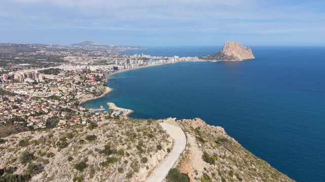 Drone flies forward over Morro de Toix toward the coast of Calpe, Spain.