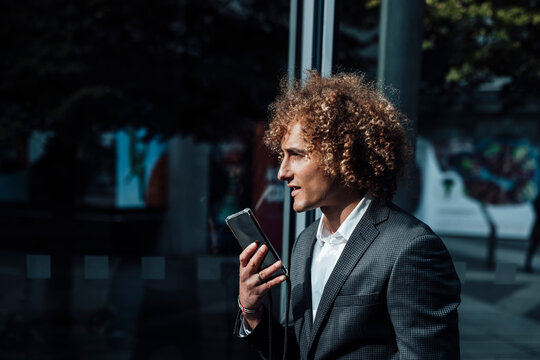 Businessman sending voicemail through mobile phone