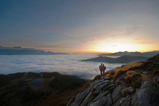 Hiker with backpack enjoying sunrise view at Reiteralm in Austria