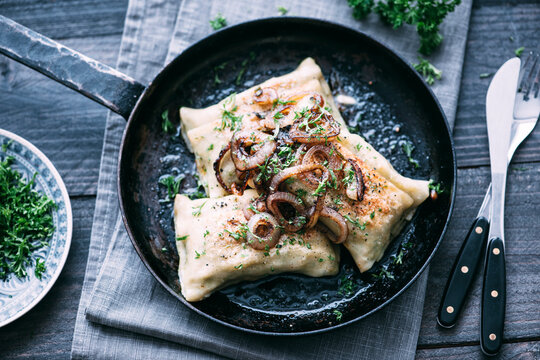 Vegetarian Swabian pockets with roasted onions in frying pan