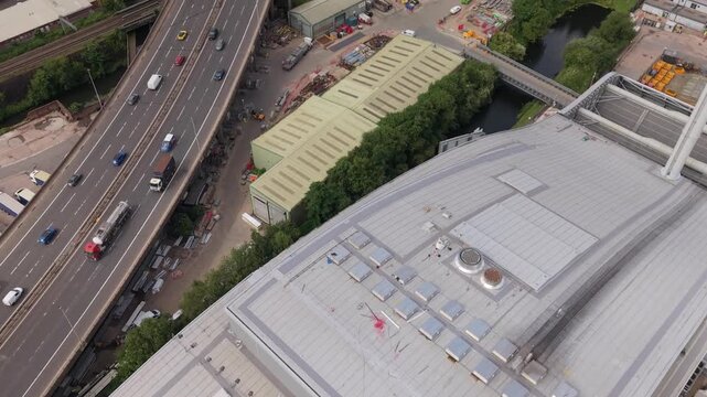 Aerial drone footage showing traffic on the M5 motorway beside a modern energy recovery facility in the West Midlands, England. Industrial infrastructure, transport network and urban development.