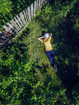 Aerial view of mid adult woman resting on grassy land in garden