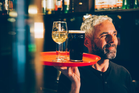 Waiter holding traywith beverages in an Irish pub