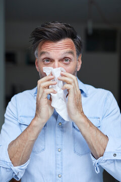 Portrait of man blowing nose