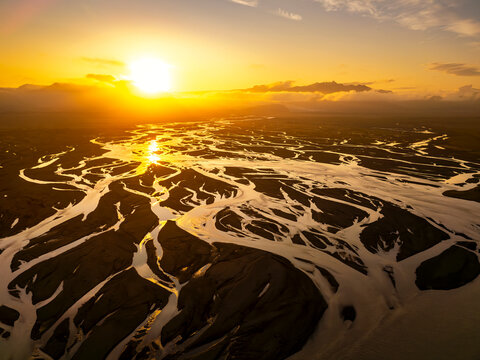 Aerial view of braided river in Iceland under midnight sun