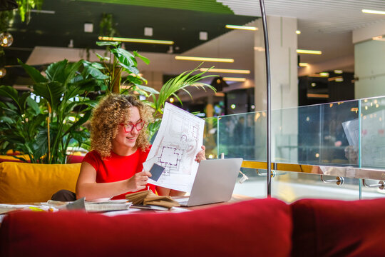 Architect presenting blueprint on laptop in biophilic workspace