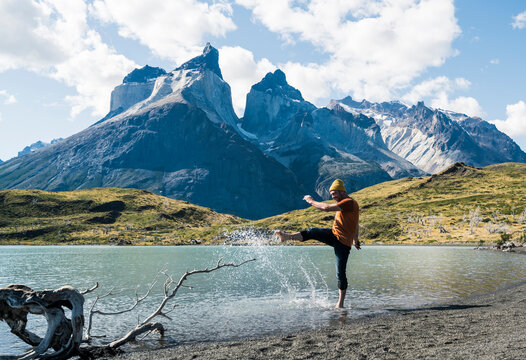 Tourist kicking water at lake in Torres del Paine