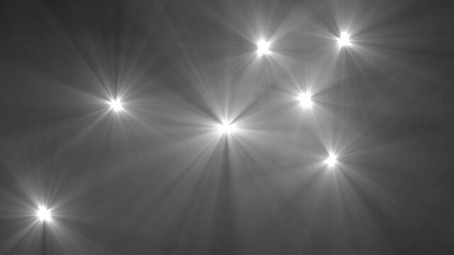 Paparazzi flashes of cameras on a black background. Camera flashes light animation overlay. Bright Lens Flares and Light Rays on a Dark Textured Background