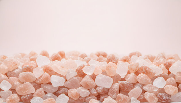 Macro pink Himalayan rock salt crystals on light background with generous copy space for wellness and food banners.