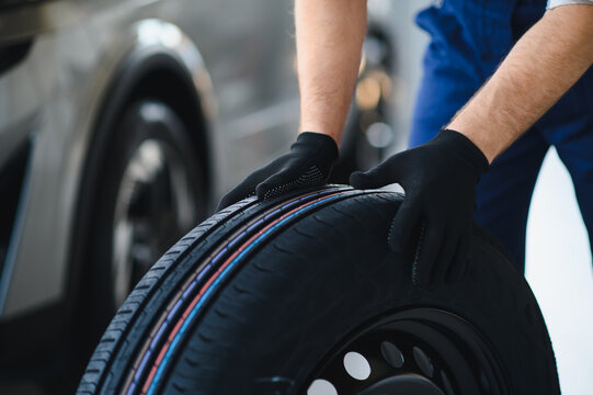 Mechanic handling car tire during automotive service