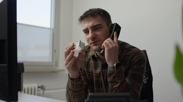 Business professional speaking with product support while inspecting a device component in an office. Concept of troubleshooting, customer service, technical assistance, and problem resolution