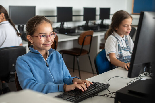 Smiling Elementary School Girl Using Desktop Computer