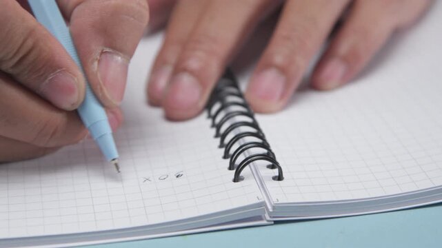 Close Up of a Pen Writing Basic Math Problems in an Exercise Book, Highlighting Education, Learning, Handwriting, Mathematics Practice, Schoolwork, and Student Study