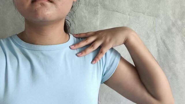 Woman stretching and touching shoulder after computer work, office fatigue, muscle tension, back pain and sedentary lifestyle concept.