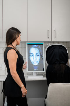 Aesthetics practitioner discussing skin analysis results during client consultation