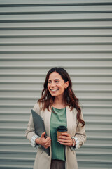 Fototapeta premium Happy woman holding laptop and coffee, smiling for career success and business professionalism