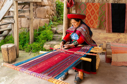 Andean woman weaving colorful textile on traditional loom in Peruvian village