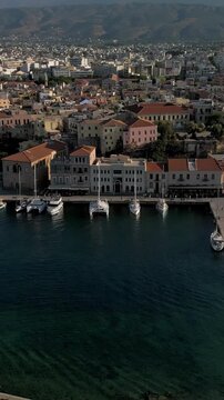 Vertical aerial view of the Old Venetian Port of Chania with breakwater, marina and stone dry docks, Crete, Greece