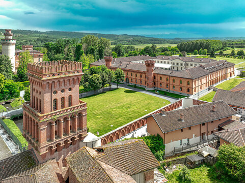 Aerial view of the University of Gastronomic Sciences campus featuring historic red brick architecture, towers, and a central green courtyard in Pollenzo, Piemonte, Italy.