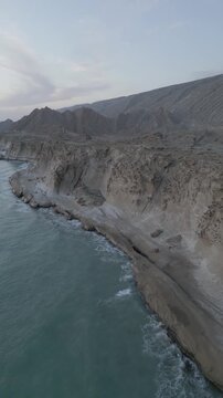 Mountain ocean near the cliff erosion environment and Martian landform landscape of peak beach sea yardang and wind polish in Iran aerial adventure in scenic sunset in Oman coastline of horizon gulf