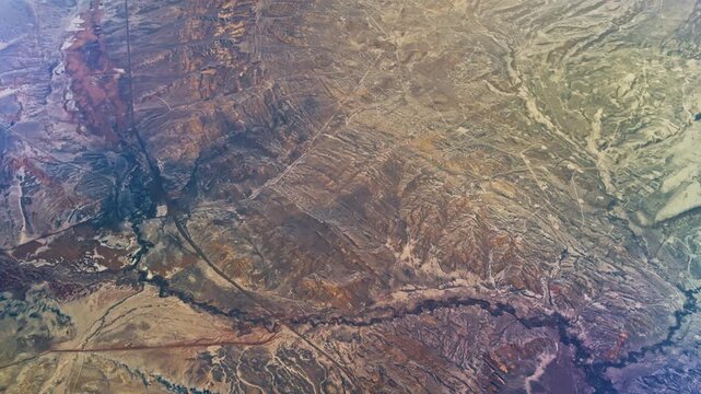 Intricate erosion patterns and winding valleys etched into ancient terrain, aerial