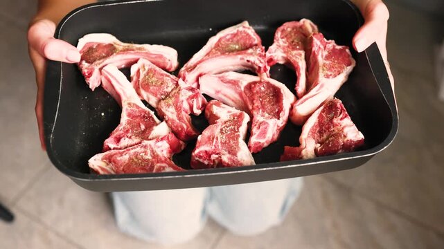 Fresh lamb rack with bones prepared for barbecue grilling and oven cooking in professional kitchen food preparation workflow.
