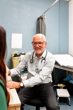 Male doctor consulting with a patient in an examination room