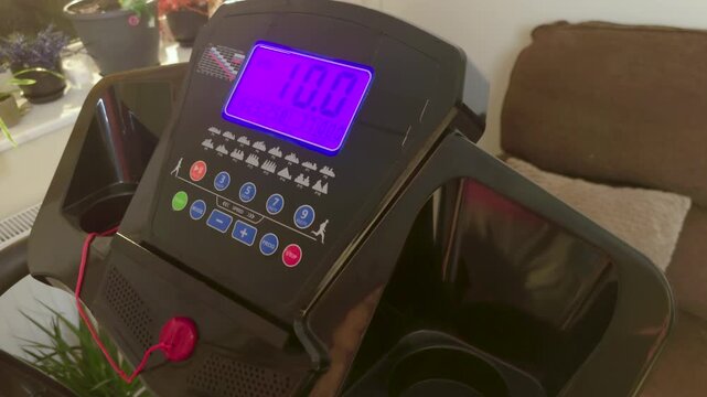 Digital treadmill display showing running speed distance calories during cardio workout home fitness equipment. Electronic console panel monitoring training metrics running program settings indoor