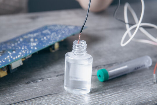 Technician repairing broken electronic circuit board with  and soldering iron