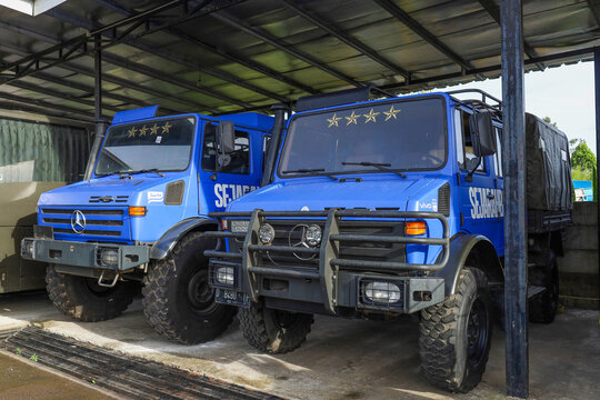 Bandung, West Java, Indonesia - May 23, 2026: Two Rugged Off Road Utility Trucks Parked Side By Side Under Metal Shelter With Heavy Duty Tires