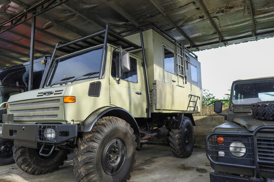 Rugged Off Road Camper Truck With Large Tires And A Tall Roll Cage Is Parked