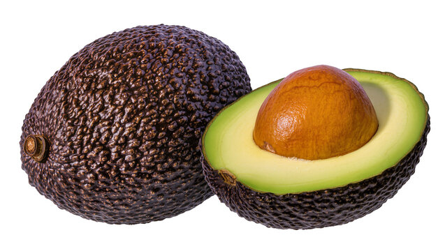 Whole and halved Hass avocado with pit and green flesh