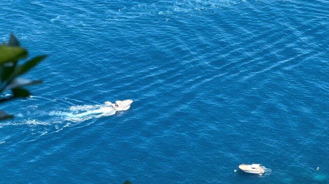 Luxury Motorboat on the Deep Blue Mediterranean Sea Near Capri Island Naturally Framed by Green Foliage, Campania Italy

