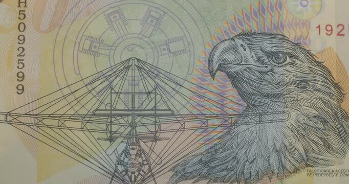 Macro view of the Romanian ten lei banknote, featuring the portrait of aviation pioneer Aurel Vlaicu, an eagle, and his Vlaicu II airplane design, showcasing the detailed security features