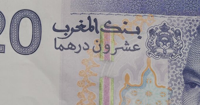Detailed close-up view of a Moroccan 20 dirham banknote, highlighting the portrait of King Mohammed VI, intricate patterns, and Arabic text in a smooth sliding motion over the currency