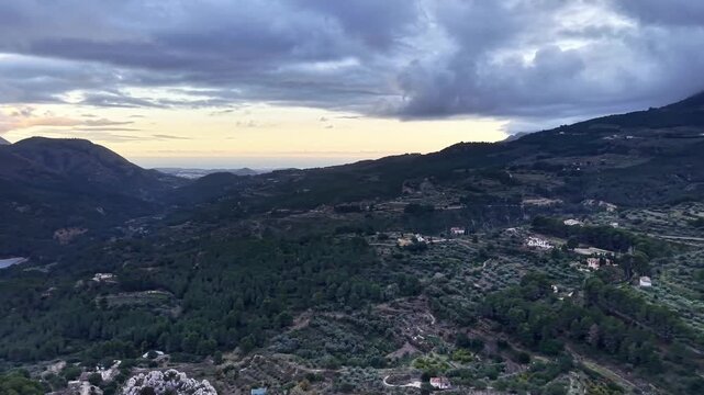 Aerial terraced farmland at twilight with olive groves and vineyards, patchwork fields and stonewalls, rural
