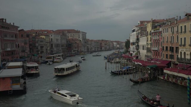Busy Grand Canal in Venice with boats and gondolas on a cloudy hazy day